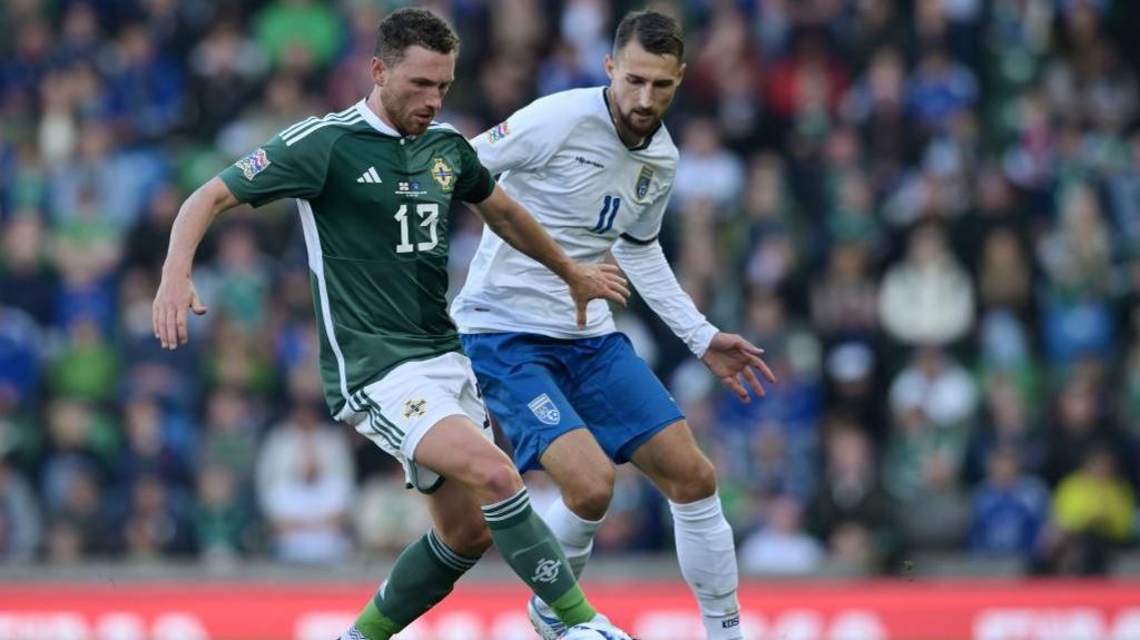 Evans shields the ball against Kosovo