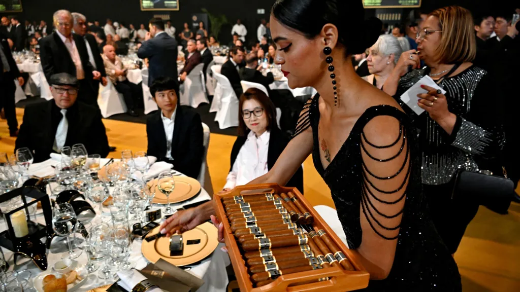 A woman distrubutes cigars at the closing ceremony of the 2025 Habanos Festival