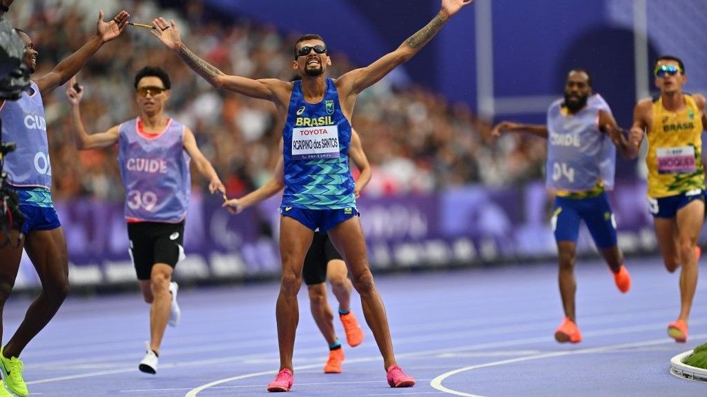 Brazil jock Julio Agripino dos Santos raising his arms aft winning golden successful nan men's T11 5000m astatine Paris Paralympic Games 