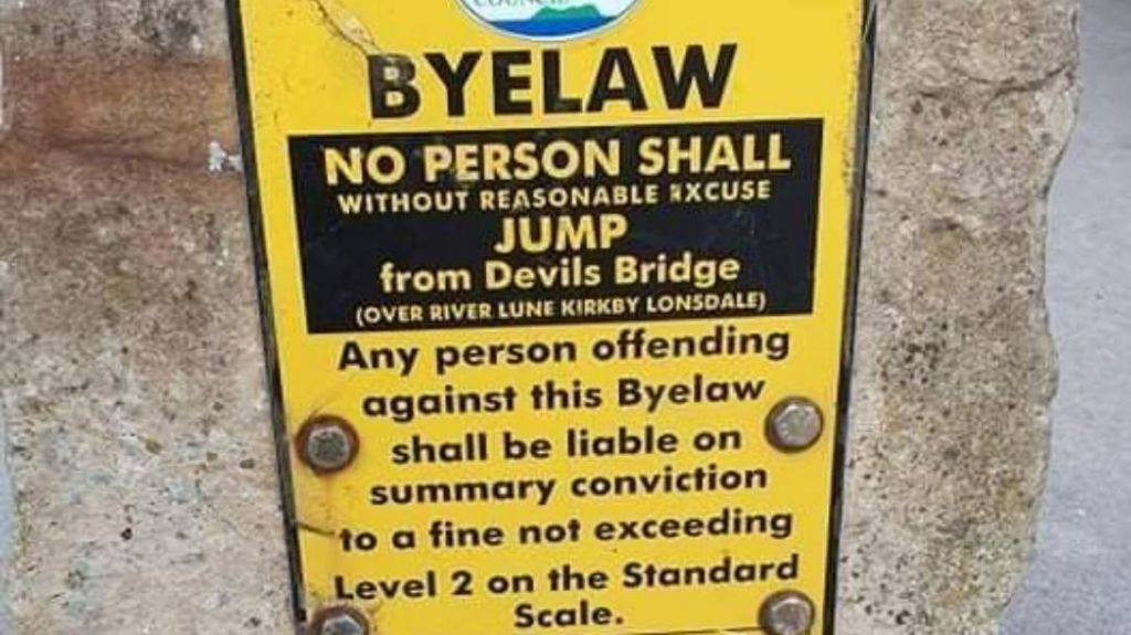 A yellow sign reading: "BYELAW No person shall without reasonable excuse jump from Devils Bridge".