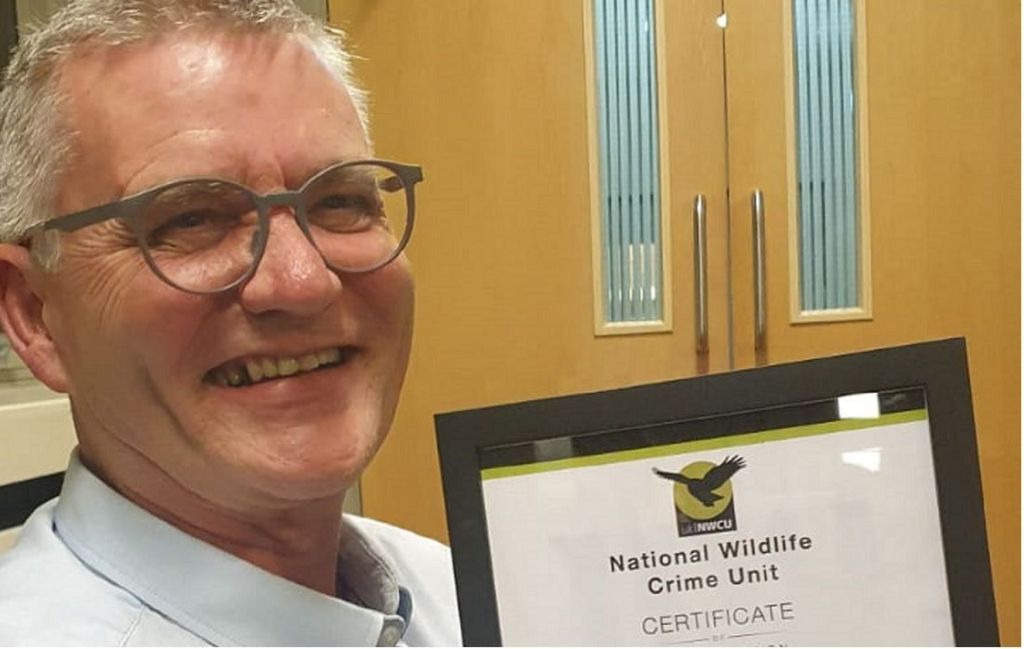 Craig Fellowes with a certificate he previously received from the National Crime Unit 