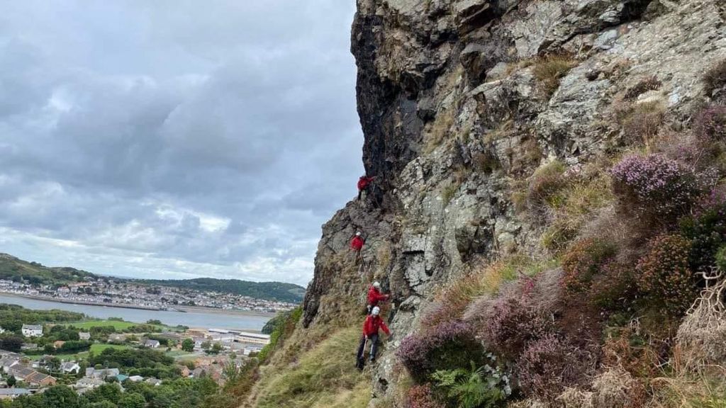 Mountain rescue volunteers on cliff