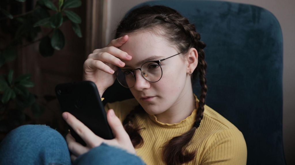 A stock image of a girl looking at a phone