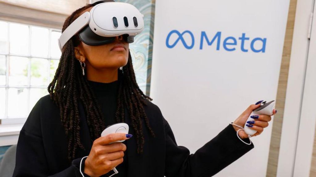 A woman using the Quest 3 headset. It is white, clean and goggle-shaped. However, it looks less sleek and futuristic than Apple's product. In comparison, you would struggle to argue it looks as cool as the Vision Pro.