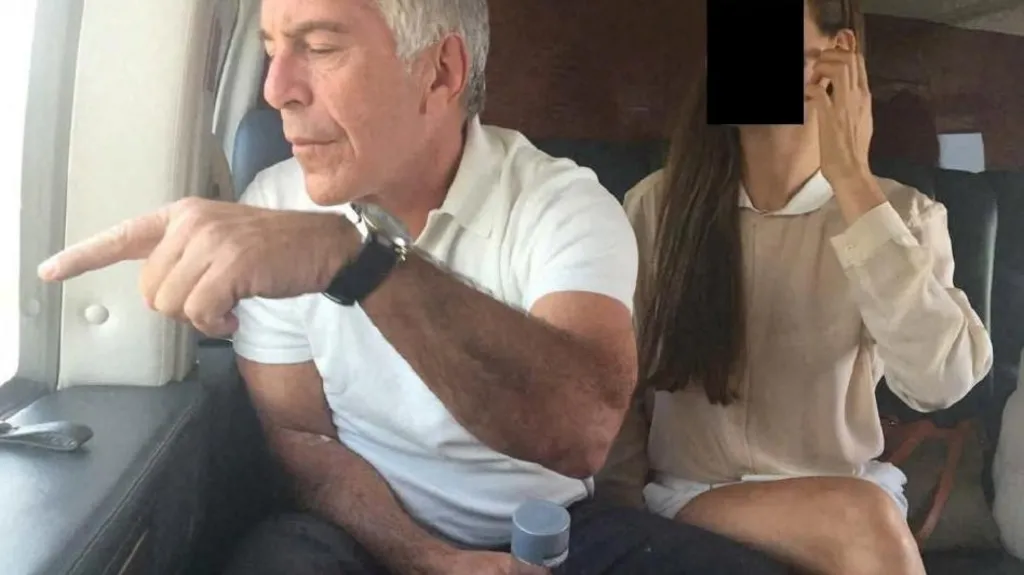 Jeffrey Epstein points out of a window sat next to a woman whose identity has been obscured 