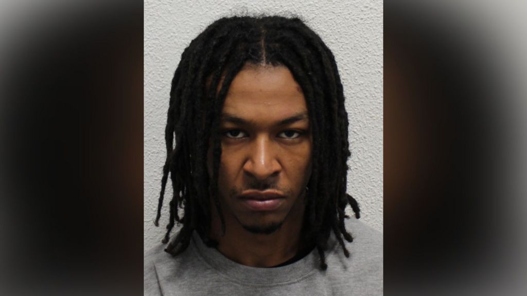 Police mugshot of Nathan Tokosi, wearing a grey sweatshirt and looking at the camera with a grumpy face.