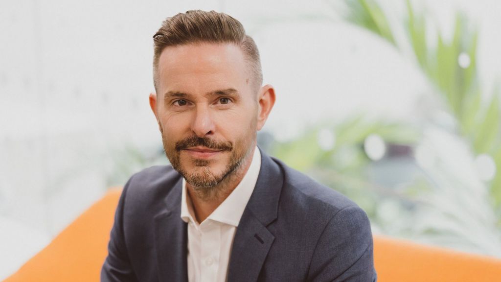A headshot of ousted National Savings and Investments boss Dax Harkins wearing a grey suit with a white shirt.