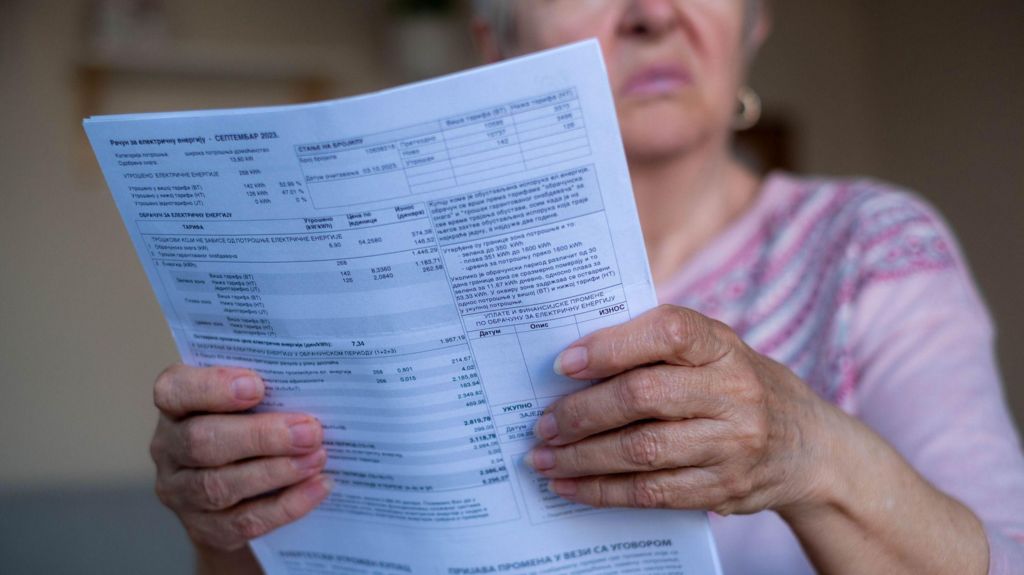 Older lady holding household bills