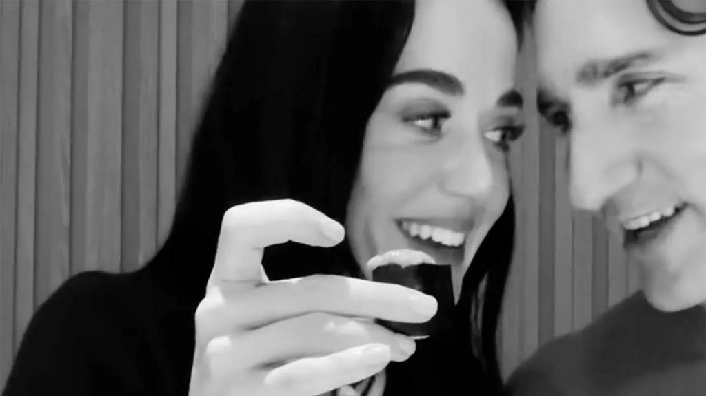A black and white picture of Katy Perry and Justin Trudeau trying sushi together