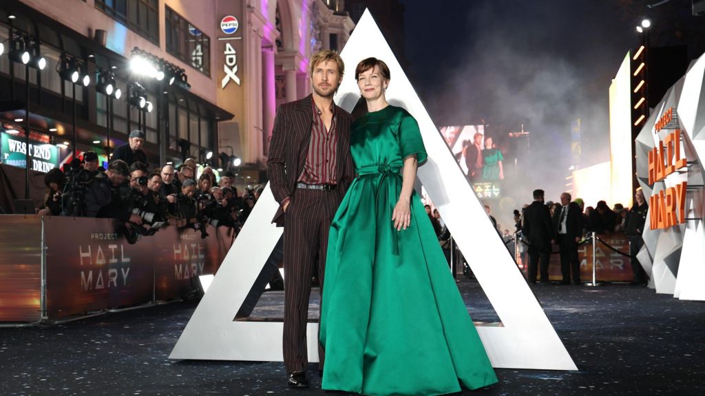 Ryan Gosling and Sandra Hüller at the Project Hail Mary premiere in Leicester Square, he's in a striped suit and shirt in dark and deep red, she is in a full-length green dress.