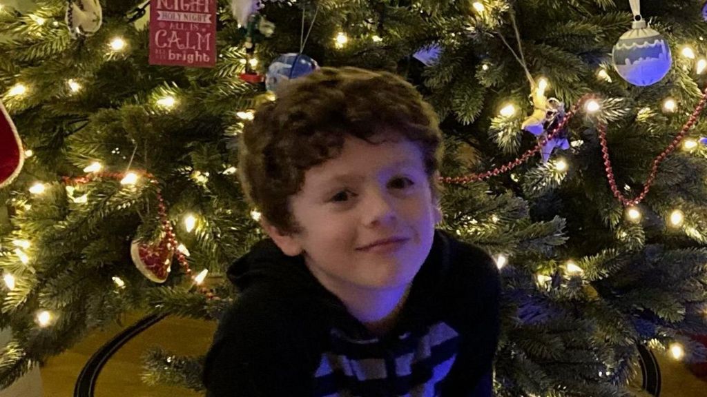 Dylan Cope in front of a Christmas tree