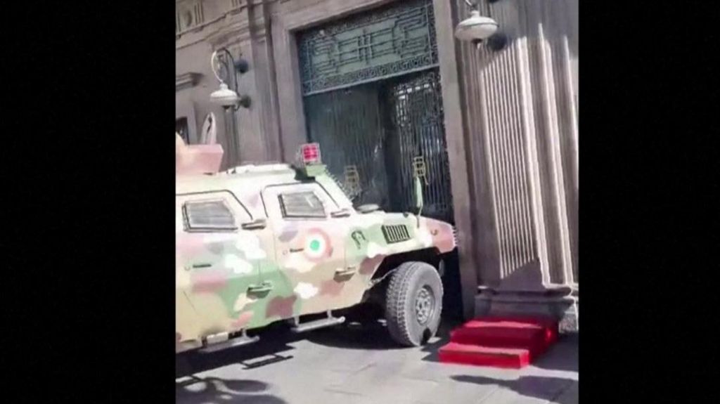 An armoured vehicle rams a set of doors