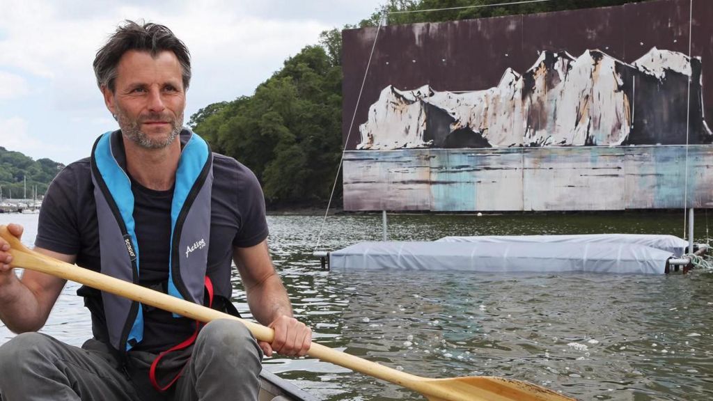 Anthony Garratt rowing near one of the paintings