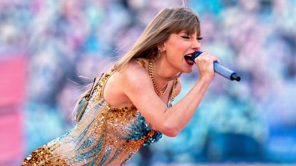 Taylor Swift singing into microphone at Edinburgh Murrayfield stadium in June 2024