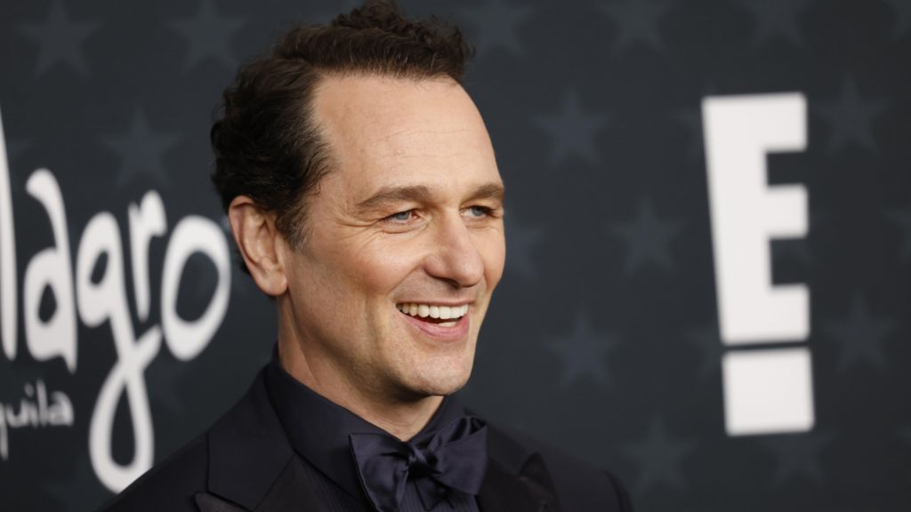 Matthew Rhys smiling in a black bow tie at a premiere