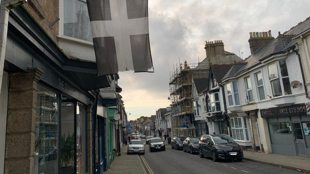 The high street in Camborne with a St Piran flag in the foreground
