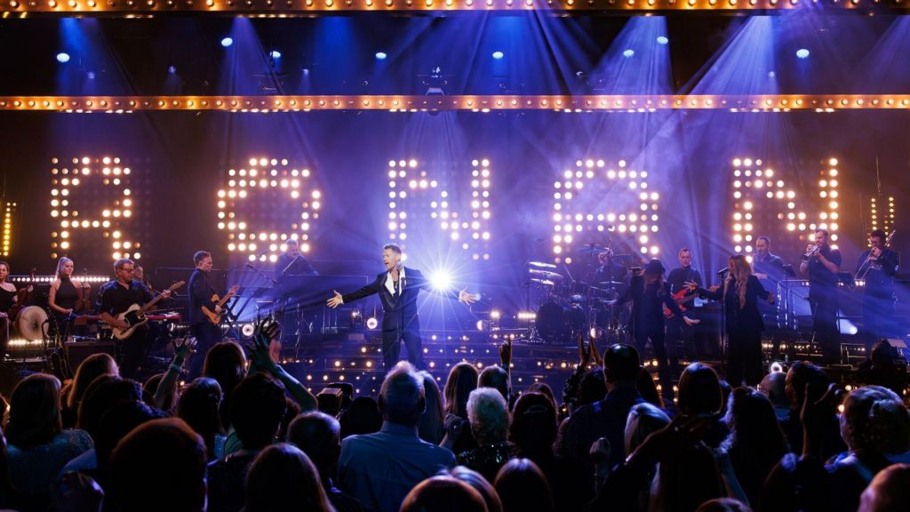 A wide shot of Ronan Keating on stage for tonight's concert in front of giant letters made out of lights, spelling his first name.