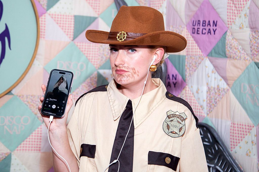  Amelia Dimoldenberg shows how she's listening to a Lily Allen song while dressed as a sheriff