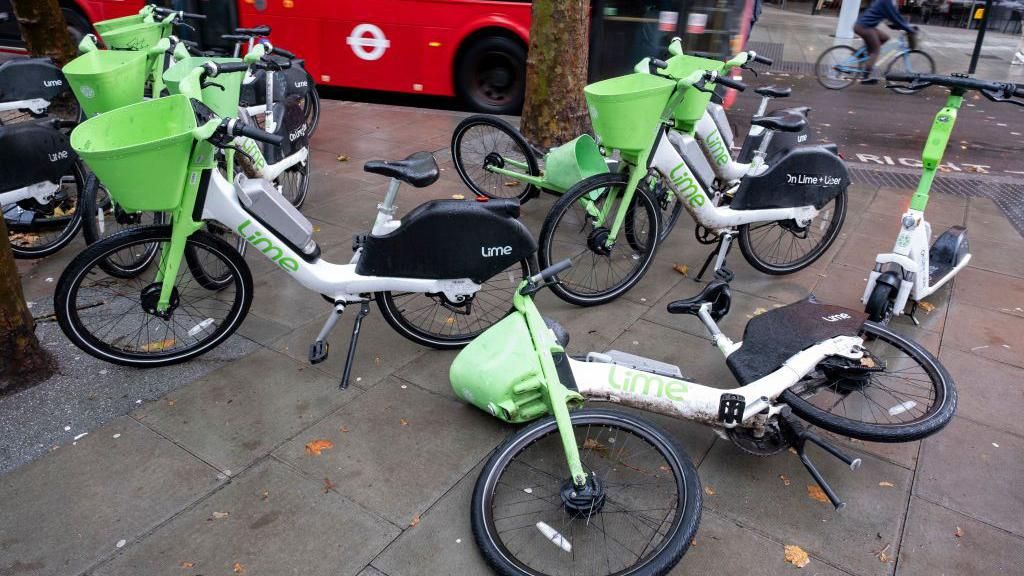 Lime electric bicycles parked and fallen across the pavement in central London