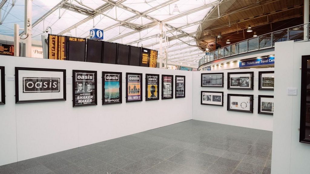 A pop-up Microdot Design exhibition featuring iconic 1990s Oasis artwork by Brian Cannon on display at Manchester Piccadilly train station
