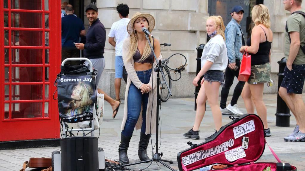 Female busker performs in Covent Garden.