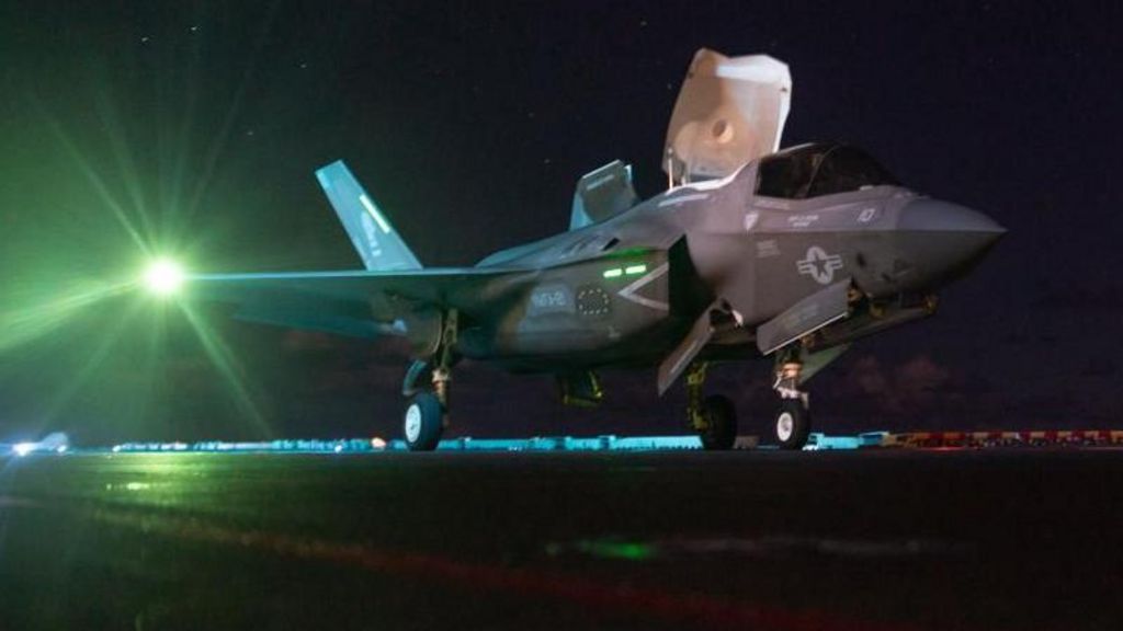 A US F-35 fighter on an aircraft carrier with a night sky