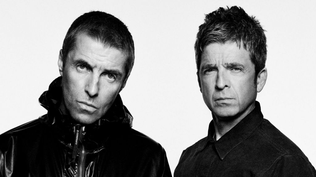 Liam and Noel Gallagher stare at the camera for a promotional photograph.