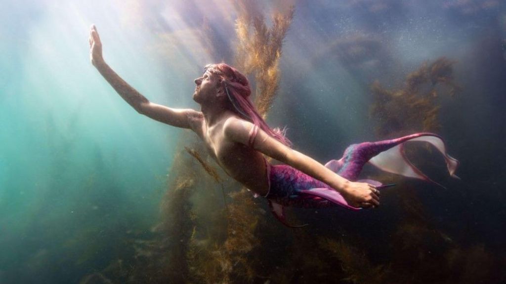 Lukas Stevenson under water wearing a mermaid tail