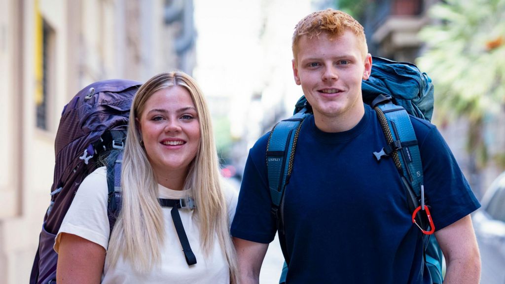 Brother and sister Harrison and Katie with their backpacks on, smiling at the camera