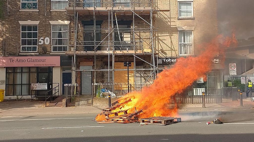 Fire burning on Spring Bank in front of a building covered by scaffolding