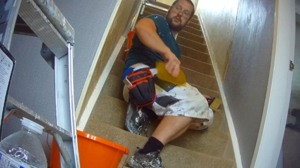 Aaron Watkins wallpapering the stairs of a house