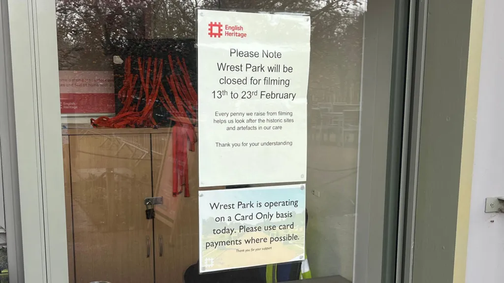 A glass door with two printed English Heritage notices taped to it. The top sign announces that Wrest Park will be closed for filming from 13th to 23rd February.