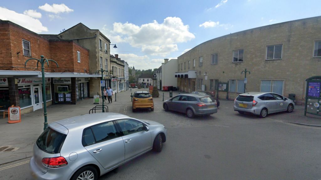 Cars on a road turning into a pedestrianised area blocked by bollards