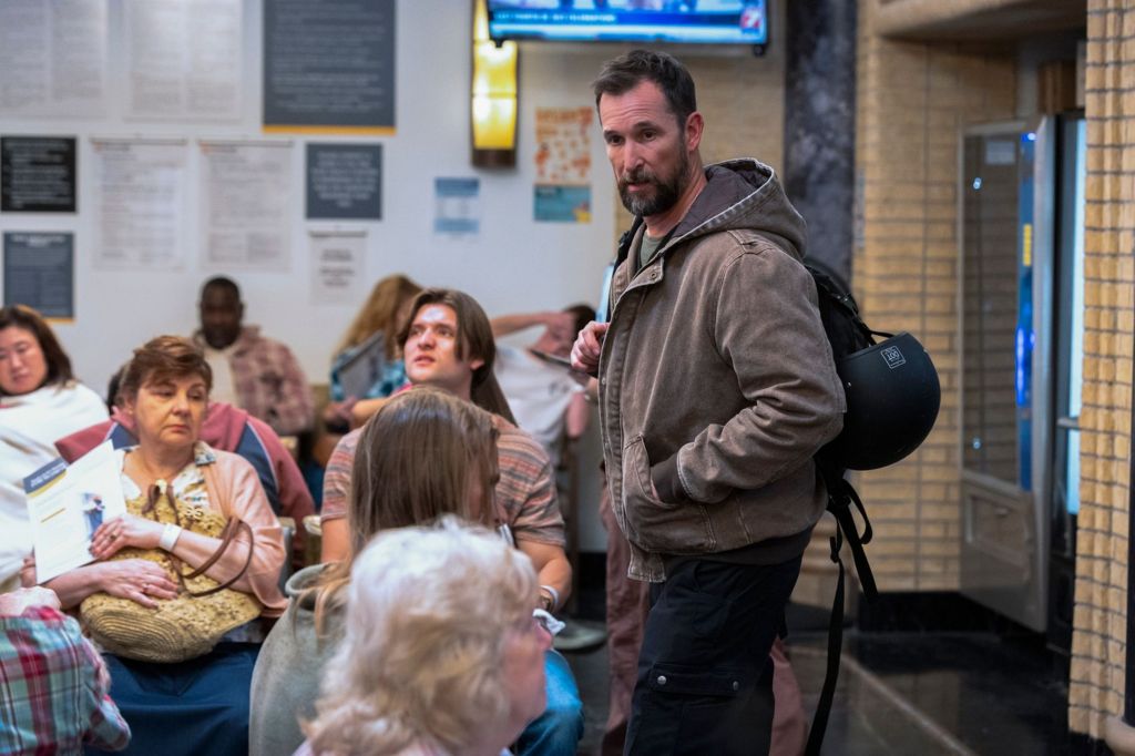 Dr Robby (Noah Wyle) arrives in the waiting room of the hospital A&E department