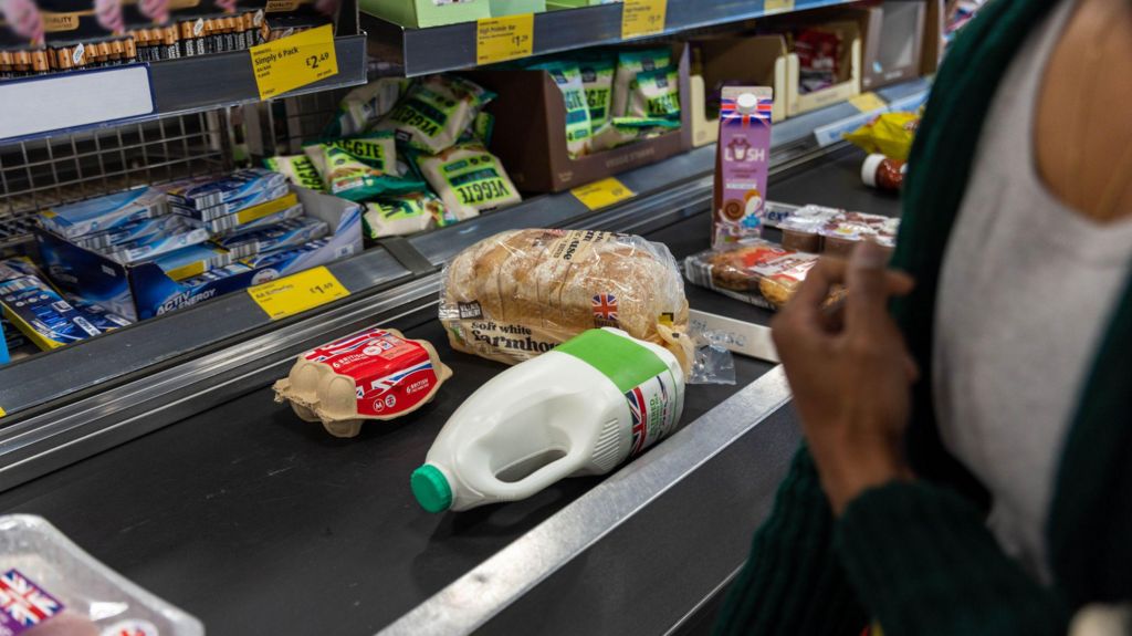 Eggs, bread, milk, and other food on a conveyor belt