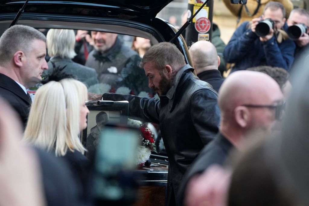 David Beckham, seen touching Mani's coffin, bids farewell to one of his musical heroes