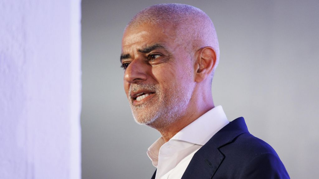 Sadiq Khan in a blue suit and white shirt.