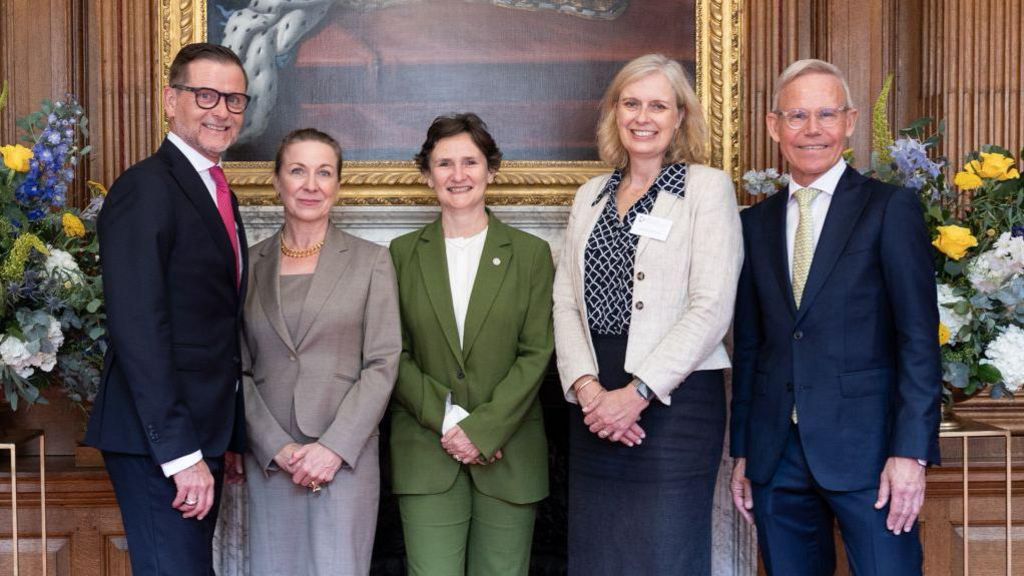 Left to right: Reto Larsson, Dr Katharina Lichtner, managing director of Family Larsson-Rosenquist Foundation, Professor Irene Tracey, University of Oxford vice-chancellor, Professor Krina Zondervan, head of Nuffield Department of Women's & Reproductive Health, Michael Larsson, founding and honorary president of Family Larsson-Rosenquist Foundation. They are smiling at the camera. There are flowers and a painting at the background.