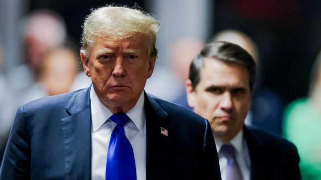 Trump departs a New York court after a jury found him guilty of 34 felony counts on 30 May. His lawyer, Todd Blanche, is seen over his shoulder.