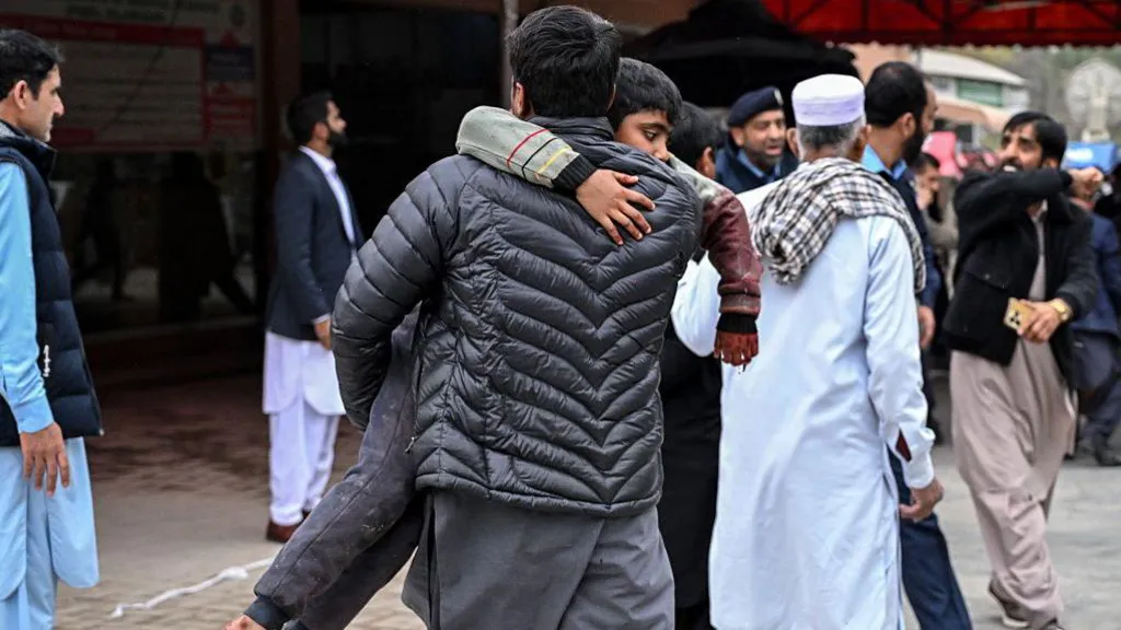  A man carries an injured boy to a hospital following an explosion at a mosque in Islamabad on February 6, 2026