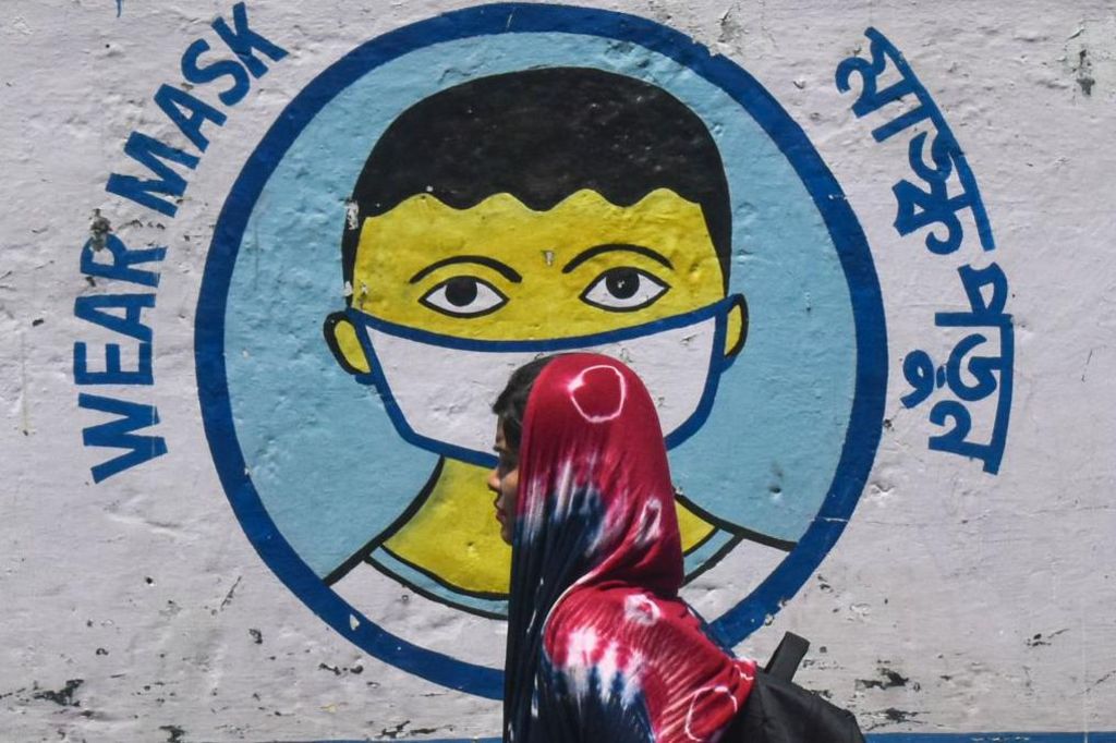 Women walk past a coronavirus (COVID-19) themed mural on a street in Kolkata, India on 02 April 2023.