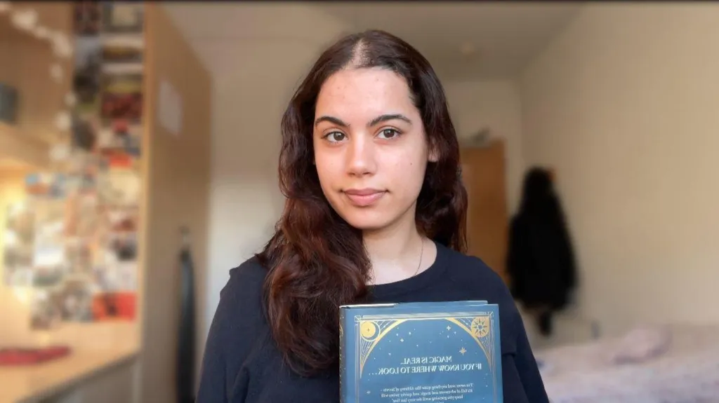 A woman with black hair and a black top.