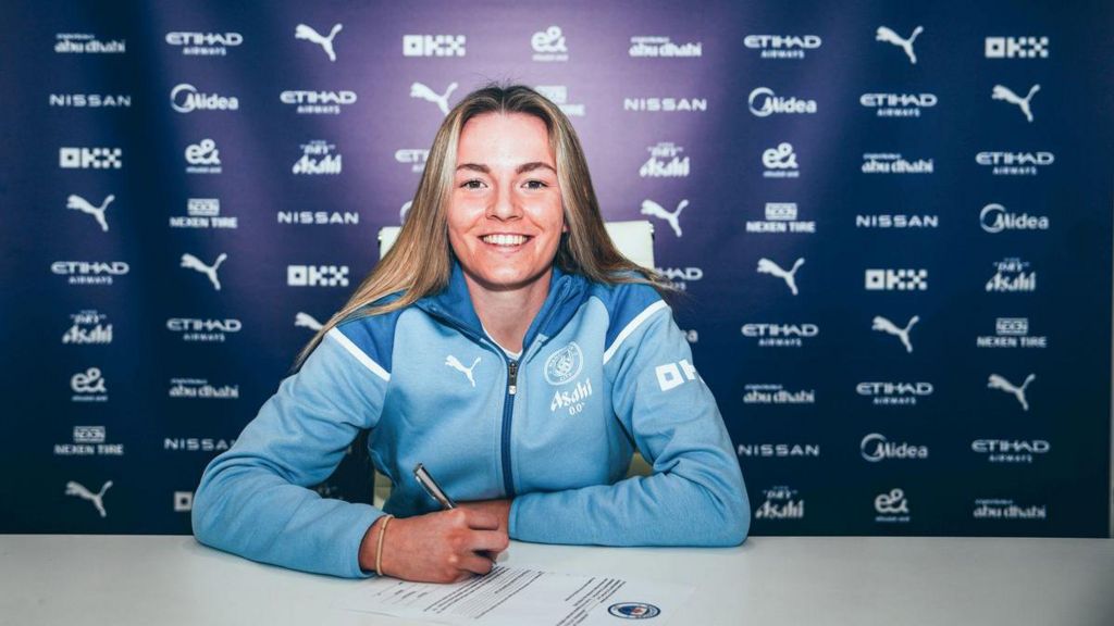 Lauren Hemp smiles as she signs her contract