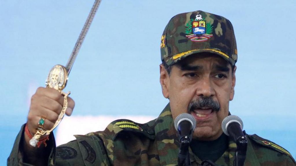 Venezuela's President Nicolas Maduro holds Simon Bolivar's sword as he addresses members of the armed forces