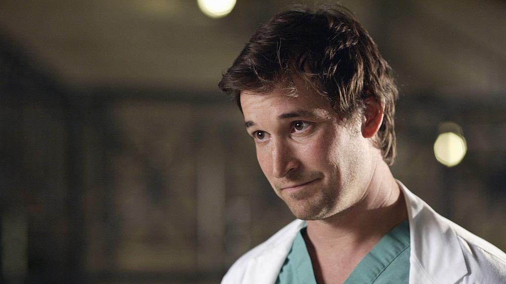 Noah Wyle as Doctor John Carter in TV show ER. He's pictured in scrubs, looking away from the camera. 