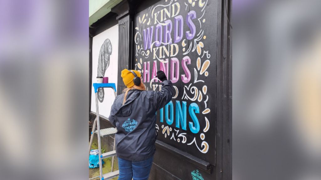 An artist painting her wall