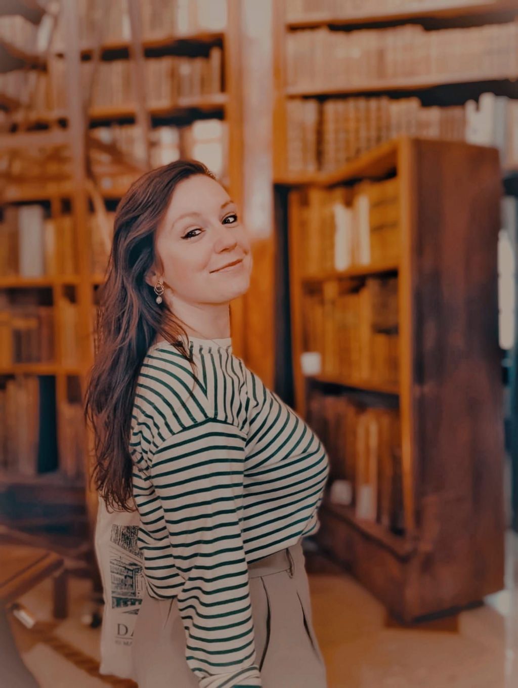Laura Anne, a white woman in her 20s, in a library on holidays