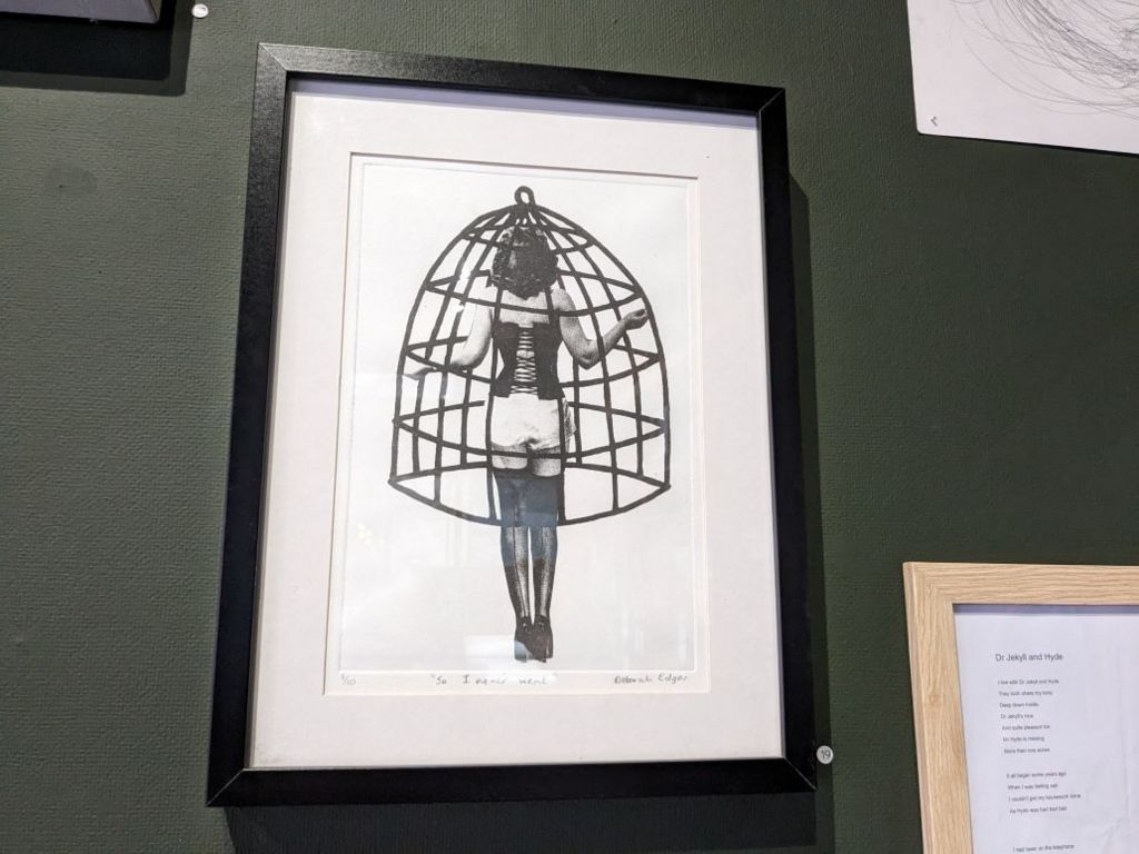 artwork in which a woman holds a cage around herself