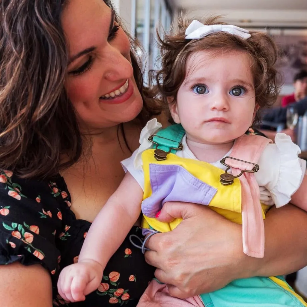 Vicki and one of her children sitting at a dining table in a restaurant - other customers can be seen in the background