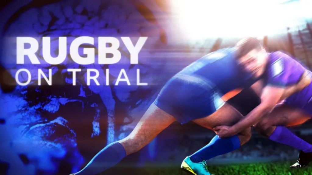 Two rugby players in blue kit tackling each other on a poster with the words " RUGBY ON TRIAL" in bold white letters against the backdrop of a brain scan picture